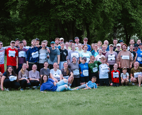 Etwa 50 Läuferinnen und Läufer unterschiedlichen Alters stehen erschöpft, aber glücklich vom Spendenlauf auf einer Wiese im Liebenzeller Kurpark. Für ein Gruppenfoto haben sie sich versammelt. Die Gruppe lächelt in die Kamera – dankbar und stolz, den Lauf erfolgreich geschafft zu haben.