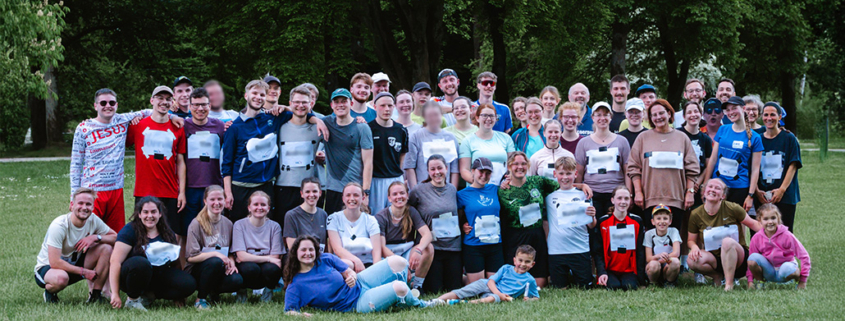 Etwa 50 Läuferinnen und Läufer unterschiedlichen Alters stehen erschöpft, aber glücklich vom Spendenlauf auf einer Wiese im Liebenzeller Kurpark. Für ein Gruppenfoto haben sie sich versammelt. Die Gruppe lächelt in die Kamera – dankbar und stolz, den Lauf erfolgreich geschafft zu haben.