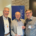 Prof. Roland Deines überreicht Prof. Karl-Wilhelm Niebuhr im Beisein von Jens Herzer am Stand des Mohr Siebeck Verlags das erste Exemplar des neuen CJHNT-Tagungsbands. Die drei Wissenschaftler stehen lächelnd nebeneinander, während Prof. Niebuhr das Buch in den Händen hält.