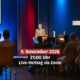 Veranstaltungshinweis für einen Live-Vortrag via Zoom mit Prof. Dr. Markus Zehnder. Das Bild zeigt einen Redner an einem Pult auf einer beleuchteten Bühne mit großem Kreuz neben einem Publikum, überlagert mit den Textangaben Datum 9. November 2026, 21:00 Uhr und Live-Vortrag via Zoom.