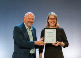 Alternativtext (Alt-Text): IHL-Rektor Prof. Dr. Volker Gäckle überreicht Frau Dr. Anna Fiona Weiß die Ernennungsurkunde zur Professorin an der Internationalen Hochschule Liebenzell. Beide stehen lächelnd nebeneinander und halten gemeinsam die gerahmte Urkunde in den Händen.